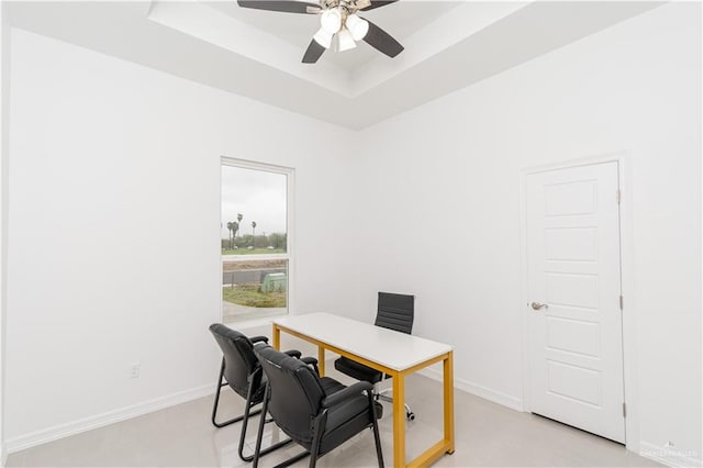 home office with ceiling fan and a raised ceiling