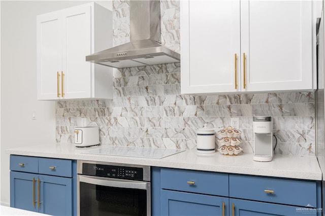 kitchen with white cabinets, oven, wall chimney exhaust hood, and electric stovetop