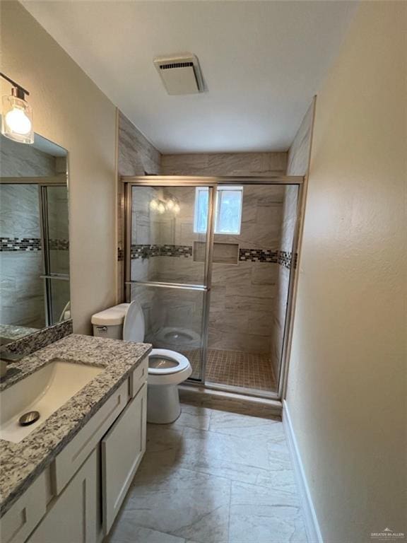 bathroom featuring toilet, vanity, visible vents, baseboards, and a shower stall