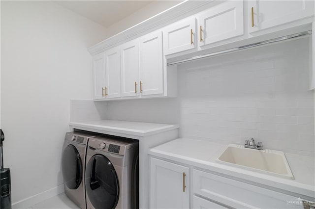 laundry room featuring cabinets, separate washer and dryer, and sink