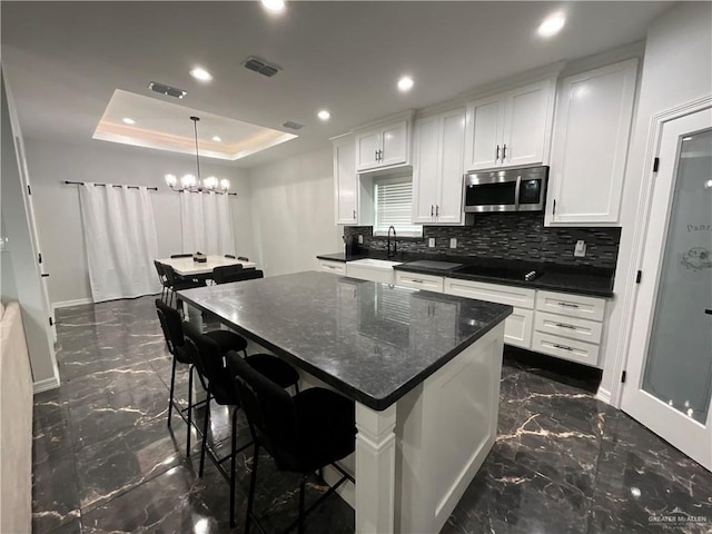 1213 Emma Elizabeth St, Weslaco, TX 78599 - kitchen featuring stainless steel microwave, dark marble finish floors, a center island, backsplash, and recessed lighting