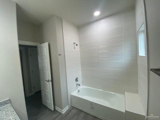 bathroom featuring wood-type flooring and tiled shower / bath combo