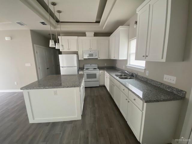 kitchen with white cabinets, decorative light fixtures, white appliances, and sink