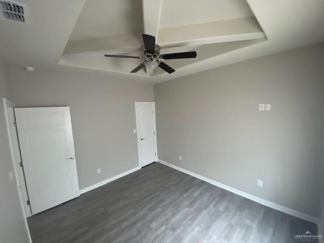 unfurnished bedroom with ceiling fan and dark wood-type flooring