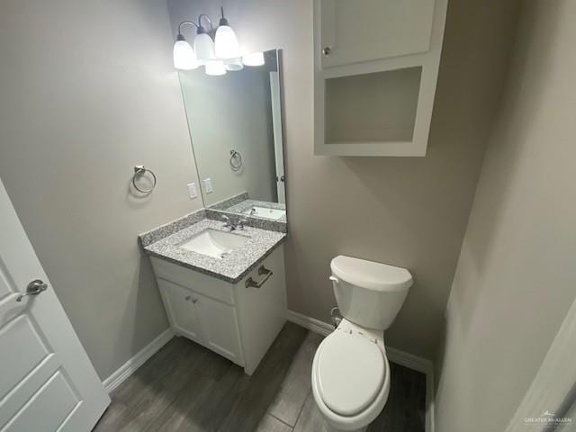 bathroom with vanity, toilet, and wood-type flooring