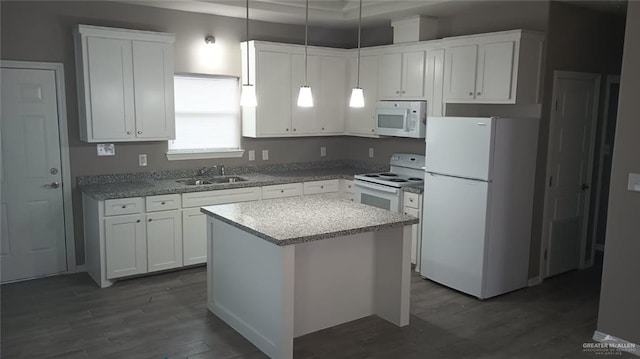 kitchen with white appliances, sink, pendant lighting, white cabinets, and a center island