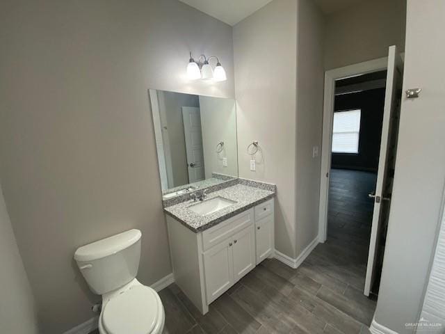 bathroom with vanity, hardwood / wood-style flooring, and toilet