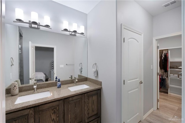 ensuite bathroom featuring connected bathroom, visible vents, a sink, and double vanity