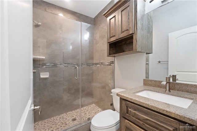 bathroom with toilet, a stall shower, and vanity