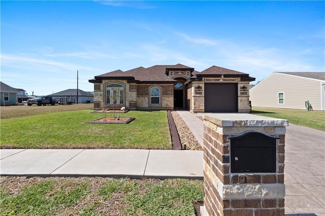 prairie-style home with brick siding, a shingled roof, concrete driveway, an attached garage, and a front yard