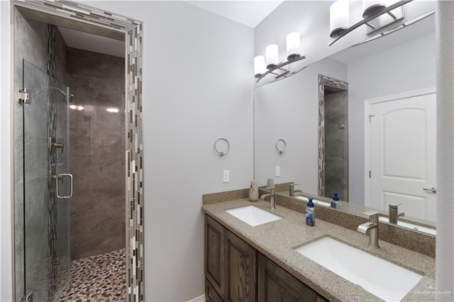 bathroom featuring a sink, a shower stall, and double vanity