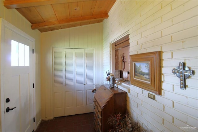 interior space with vaulted ceiling with beams, brick wall, wood ceiling, and brick floor