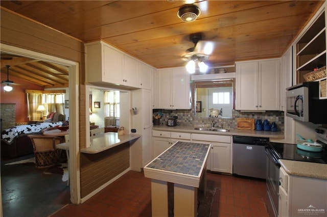 kitchen with brick floor, appliances with stainless steel finishes, white cabinetry, wooden ceiling, and tasteful backsplash