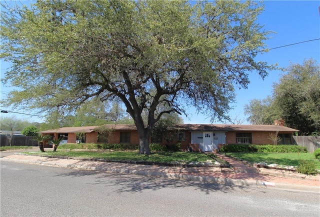 ranch-style home featuring fence