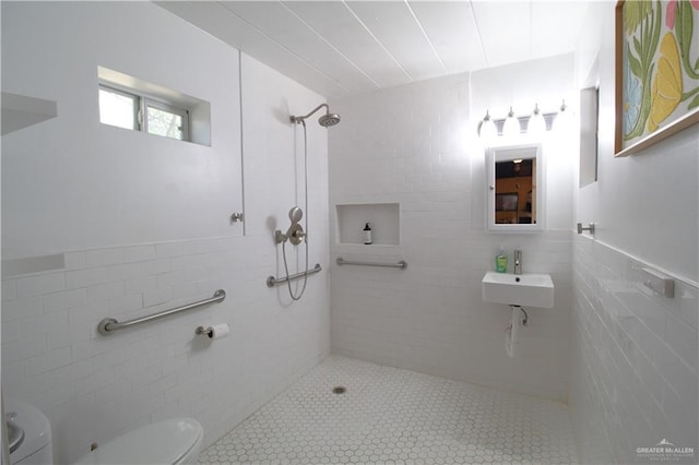 full bathroom with tile walls, toilet, a tile shower, and a sink