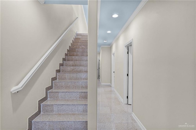 stairway featuring baseboards, crown molding, and recessed lighting