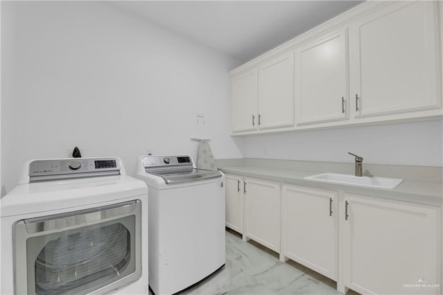 clothes washing area with cabinets, separate washer and dryer, and sink