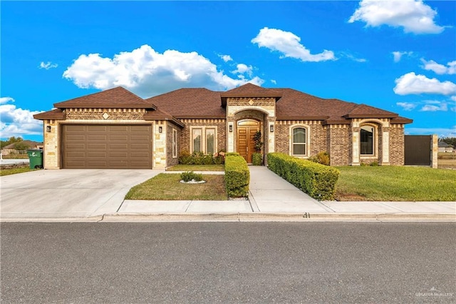 mediterranean / spanish home with a garage and a front lawn