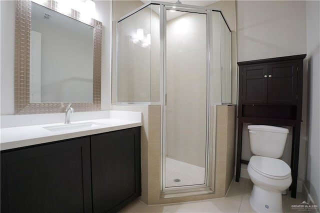 bathroom featuring tile patterned floors, vanity, toilet, and a shower with door