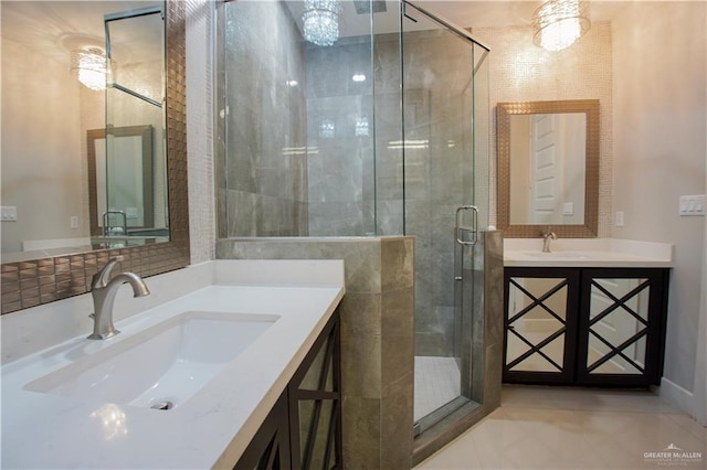 bathroom featuring vanity, an inviting chandelier, tile patterned floors, and a shower with shower door