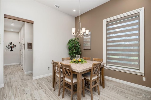 dining space featuring a notable chandelier and light hardwood / wood-style flooring