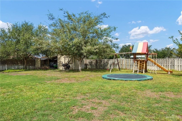 view of yard with a trampoline and a playground