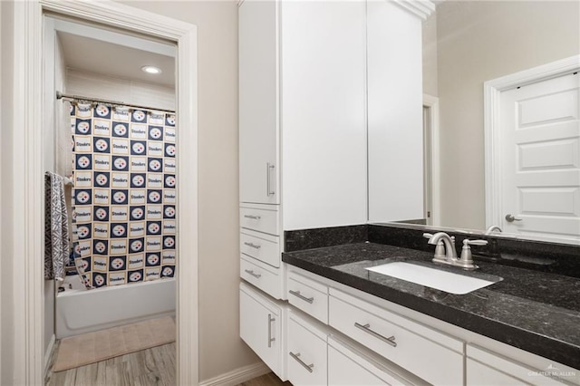 bathroom with shower / bath combination with curtain, hardwood / wood-style floors, and vanity