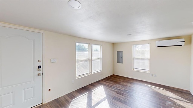 foyer with hardwood / wood-style floors, electric panel, and a wall unit AC