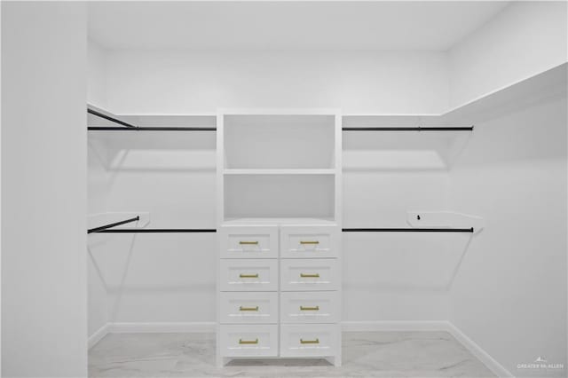 spacious closet featuring marble finish floor