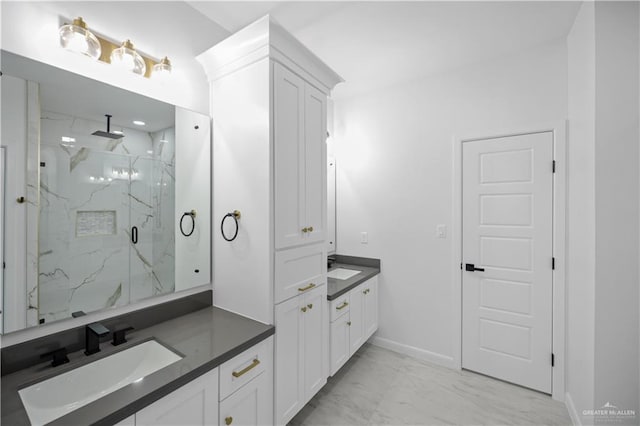 full bath with a marble finish shower, baseboards, a sink, marble finish floor, and two vanities