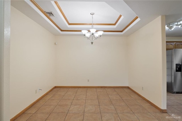 tiled spare room with a raised ceiling and an inviting chandelier