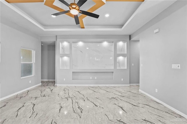 unfurnished living room featuring a tray ceiling and ceiling fan