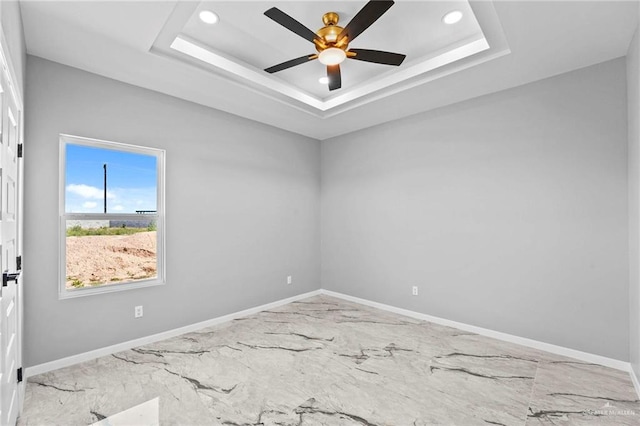 unfurnished room with a tray ceiling and ceiling fan