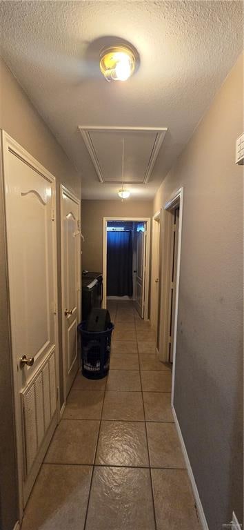 hall featuring tile patterned flooring and a textured ceiling