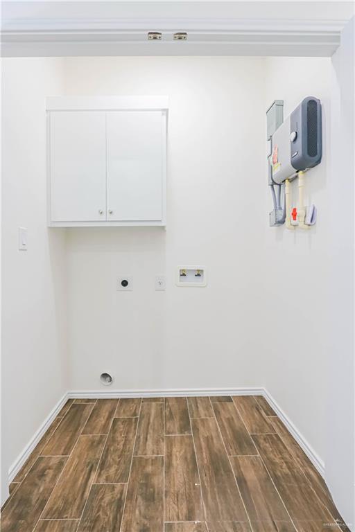 1046 Hidalgo St, Mercedes, TX 78570 - laundry room with cabinet space, dark wood-style flooring, baseboards, and electric dryer hookup