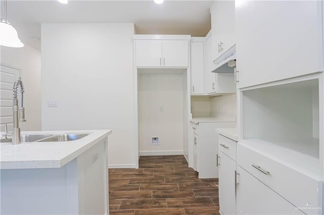 1046 Hidalgo St, Mercedes, TX 78570 - kitchen with a sink, dark wood-style flooring, white cabinetry, light countertops, and decorative light fixtures