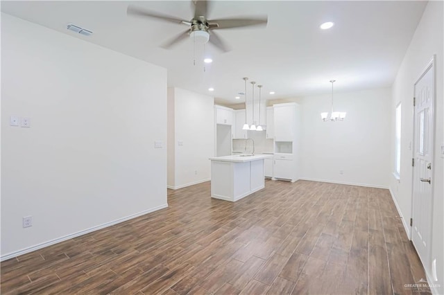 1046 Hidalgo St, Mercedes, TX 78570 - unfurnished living room featuring ceiling fan, wood finished floors, a chandelier, recessed lighting, and baseboards