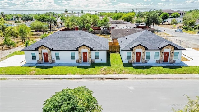 1046 Hidalgo St, Mercedes, TX 78570 - view of front facade featuring stone siding, roof with shingles, and a residential view