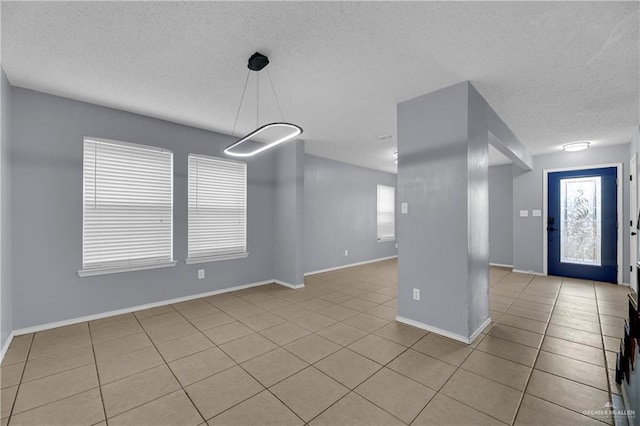 5801 N 36th St, Mcallen, TX 78504 - entrance foyer with light tile patterned floors, a textured ceiling, and baseboards