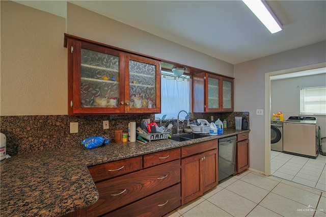 kitchen with dishwasher, light tile patterned floors, sink, backsplash, and independent washer and dryer