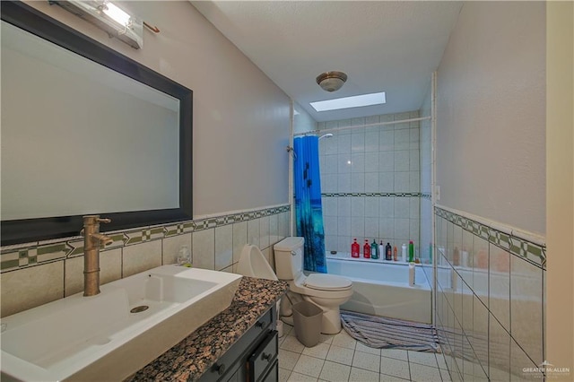 full bathroom featuring shower / bath combo, tile patterned floors, toilet, a skylight, and vanity