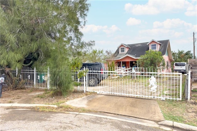 cape cod house featuring a fenced front yard