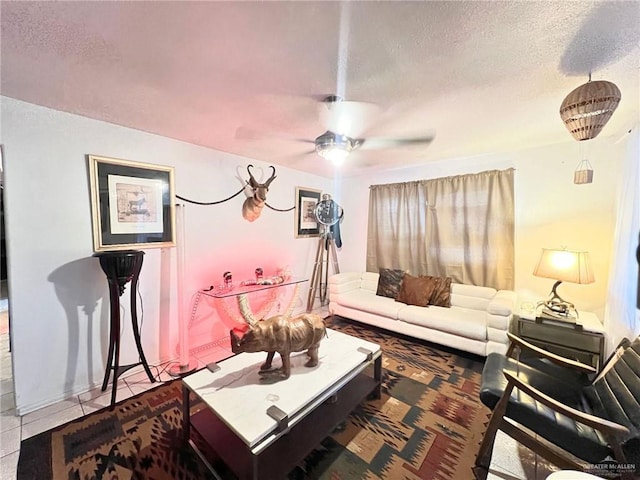 tiled living room with a ceiling fan and a textured ceiling