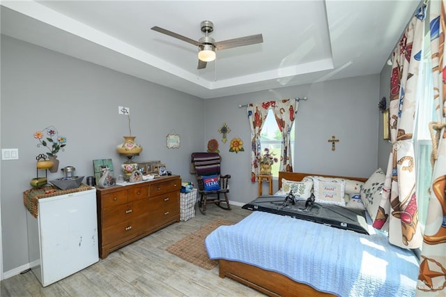 4511 Abbey St, Mercedes, TX 78570 - bedroom featuring a tray ceiling, wood finished floors, baseboards, and a ceiling fan