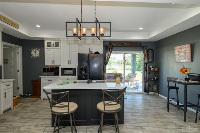 4511 Abbey St, Mercedes, TX 78570 - kitchen featuring black appliances, light countertops, white cabinets, a kitchen island with sink, and recessed lighting