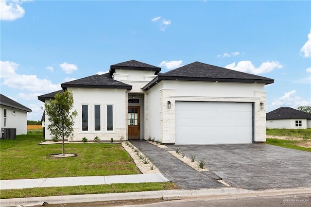 prairie-style house featuring central AC unit, a garage, and a front yard