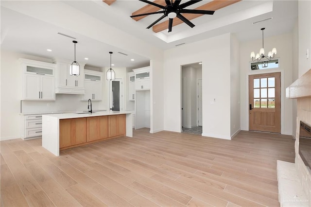 kitchen featuring pendant lighting, light hardwood / wood-style floors, white cabinetry, and a large island