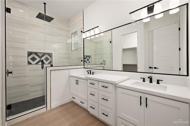 bathroom with a shower with door and vanity