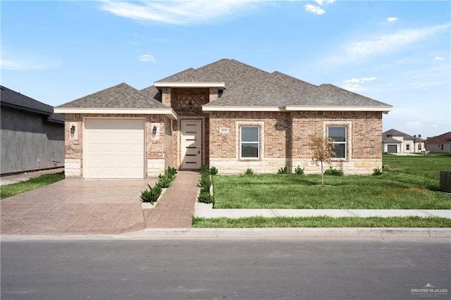 view of front facade with a garage, a shingled roof, decorative driveway, and brick siding