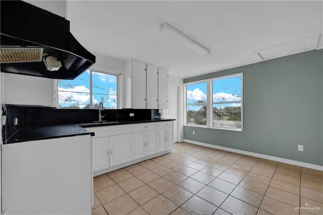 kitchen featuring light tile patterned floors, decorative backsplash, and white cabinets